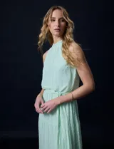 Vestido largo de gasa color verde menta, marca Julia Jordan. Tiene escote halter, cintura elastizada con lazo de ajuste y abertura central en la espalda con botones.