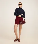 Blusa de manga larga confeccionada en viscosa sostenible, color azul marino, con cuello alto.