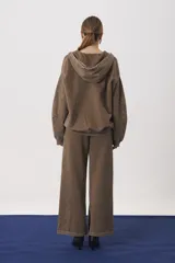 Campera con capucha y cierre frontal, confeccionada en tejido de punto con efecto lavado. Presenta mangas largas con puños ajustados y un corte relajado.