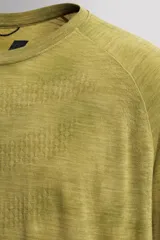 Camiseta térmica de manga larga ranglán, cuello redondo, color verde oliva con efecto tie-dye o jaspeado. Presenta tejido con lana, alta elasticidad y ajuste al cuerpo, con estructuras combinadas para facilitar la transpiración y sin costuras.