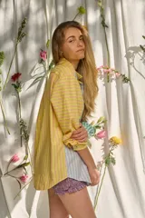 Camisa de manga larga con diseño patchwork de rayas en tonos verde, lila, amarillo y azul. Cuenta con cuello camisero, cierre frontal con botones y un bolsillo en el pecho con el logotipo bordado "pur".