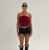 Top halter color bordó con textura de encaje floral y escote recto.