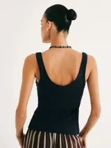 Musculosa de tela acanalada con cuello redondo y pliegues laterales que aportan textura y un ajuste entallado al cuerpo.