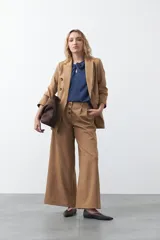 Top negro de manga corta con detalle de nudo en el escote y abertura tipo gota. Presenta una silueta relajada y textura sutil en la tela.