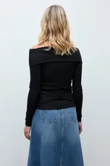 Blusa de punto con escote bardot, manga larga y ajuste al cuerpo, confeccionada en tejido con acabado brillante.