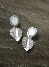 Aros colgantes plateados con forma de hoja y detalle de piedra blanca con strass.