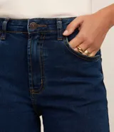 Short de jean azul oscuro, de talle medio con trabillas para cinturón, cierre de botón y cremallera, bolsillos delanteros y traseros, y costuras en contraste.