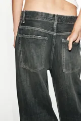 Jeans de tiro medio y corte baggy oversize con diseño de costuras marcadas en las piernas, trabillas para cinturón y cinco bolsillos tradicionales. Cierre frontal con cremallera y botón metálico.