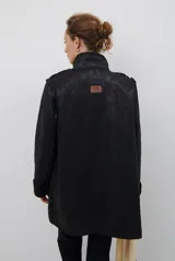 Chaquetón de efecto cuero en color marrón, con interior y detalles en corderito color bordó. Presenta cierre frontal con cremallera y botones a presión, cuello solapa y mangas largas con puños de corderito.