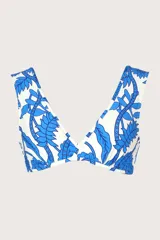 Top de bikini blanco con estampado de hojas y flores azules, de corte cruzado y breteles anchos.