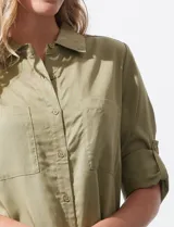 Camisa color verde oliva de lyocell, marca Cyrus. Tiene cuello con solapa, abertura central con botones, mangas 3/4 regulables con presilla y botón, y dos bolsillos delanteros aplicados.