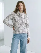 Buzo de tejido de punto con cuello vuelto que se ajusta con botones. Presenta un diseño jacquard en tonos blanco, gris y rosado pálido.