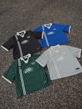 Polo de manga corta con cuello tipo polo y escote en V, corte boxy fit. Presenta un patrón texturizado en relieve y un logo ovalado con la inscripción "with love" en el pecho.