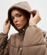 Campera puffer deportiva Get Over, color blanco con detalles de bies en color negro a lo largo de las mangas. Presenta cuello alto con capucha integrada, cierre frontal con botones a presión, bolsillos laterales con cremallera y puños con elásticos.