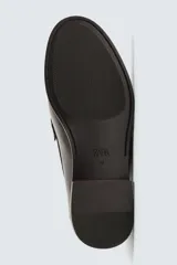 Mocasín de cuero color negro con antifaz en contraste blanco y marrón.