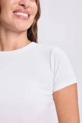 Camiseta blanca de manga corta y cuello redondo, confeccionada en tejido de punto rib al cuerpo.