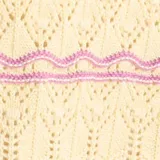 Sweater de punto fantasía color amarillo con líneas horizontales onduladas en color fucsia, de cuello redondo y manga corta.