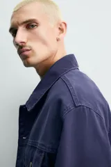 Cazadora relaxed fit de algodón en color azul marino con efecto lavado, cuello solapa, bolsillos con solapa en el pecho y cierre frontal con botones metálicos.