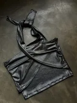 Top negro con diseño cruzado en el frente, estilo halter y con detalles de tachas doradas.