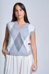 Chaleco tejido con patrón de rombos en gris, blanco y celeste, con cuello en V y sisas amplias.