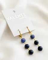 Aros colgantes con aro dorado y tres cuentas redondas de color azul en degradé.