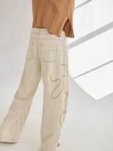 Pantalon de corte recto y tiro medio, color beige, con bordados artesanales en hilo que simulan vetas. Confeccionado en una mezcla de algodón, viscosa y lino.