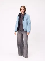 Campera puffer reversible de la marca Rusty, con diseño capitoneado. Presenta cuello alto, cierre frontal completo y logo bordado en el pecho. El interior es de un tono contrastante.