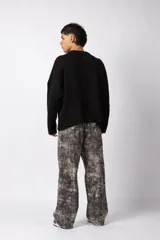 Sweater de punto color blanco con diseño de textura combinada, presentando un lado liso y otro con tejido trenzado. Posee cuello redondo, mangas largas y un corte relajado.