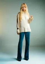 Jersey de punto de cuello alto, con diseño recto, manga larga y aberturas laterales en el ruedo.