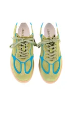 Championes de estilo deportivo retro, confeccionados en una combinación de cuero y gamuza en tonos verde palta y detalles en azul vibrante. Presentan suela de goma color caramelo con textura estriada y cordones al tono.