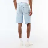 Bermudas de denim de corte clásico en color celeste claro, con bolsillos laterales y traseros, y cierre frontal con botón y cremallera.