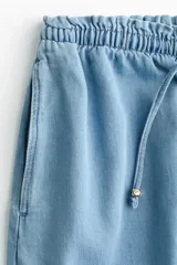 Short en denim liviano de tiro alto con cintura elástica de volado, cordón fino de ajuste y bolsillos laterales.