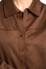 Sobrecamisa oversize de gamuza vegana marrón, con cuello camisero, mangas largas y cierre frontal de botones metálicos.