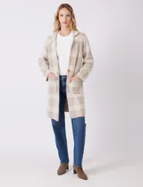 Chaqueta de tejido suave con estampado a cuadros en tonos beige y blanco, cuello con solapa y cierre de botón frontal. Incluye bolsillos delanteros.