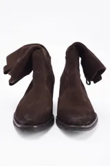 Bota corta estilo western confeccionada en cuero descarne color marrón, con taco cuadrado de madera y punta ligeramente afinada.