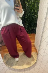 Pantalón de corte ancho y tiro alto, con cintura elástica y pinzas frontales. Presenta un diseño holgado y fluido, confeccionado en tejido de algodón.