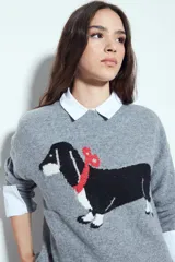 Sweater de punto color gris melange con diseño tejido de un perro salchicha en el frente. Presenta cuello redondo, mangas largas y un corte relajado.