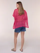 Poncho de tejido calado color beige, con mangas cortas, aberturas laterales y lazos ajustables en el cuello. Modelo Do Everything In Love.