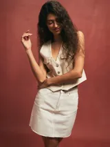 Minifalda de denim color blanco, con corte recto y tajo frontal.