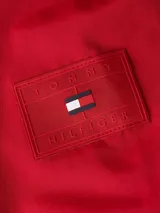 Campera roja con capucha, cierre frontal con cremallera, cuello alto y dos bolsillos laterales. Logo de Tommy Hilfiger bordado en la manga.