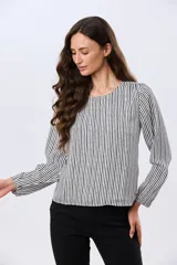 Blusa clásica de manga larga en color blanco, con cuello redondo y diseño fluido.