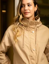 Campera color beige de poliéster, marca Michael Kors. Tiene cierre central oculto con botones a presión, bolsillos delanteros, capucha escondida en el cuello y avíos metálicos dorados con logo.