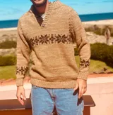 Sweater tostado de lana con cuello en V y diseño de copos de nieve en marrón.