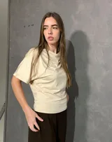 Blusa cruda de manga corta con cuello redondo y diseño fluido.