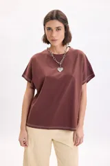 Camiseta marrón de manga corta holgada, con cuello redondo y costuras con pespuntes en color blanco contrastante en el dobladillo y las mangas.