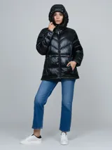 Campera puffer de Calvin Klein con acabado brillante, diseño acolchado con costuras en V, cierre frontal con cremallera, capucha integrada y bolsillos laterales con cierre.
