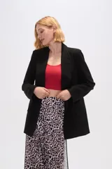 Blazer negro de lino, corte holgado, con cuello solapa y bolsillos frontales.