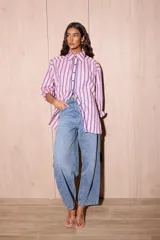 Camisa holgada de popelina de algodón a rayas verticales rosas, grises y azules. Presenta una abertura frontal con ribete festoneado en color azul marino y botones oscuros.