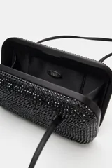 Bolso de hombro rígido con formato de caja rectangular, color negro, completamente revestido con apliques brillantes. Cuenta con doble asa de hombro delgada y cierre imantado.