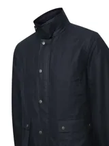Chaqueta de estilo campestre confeccionada en tela encerada impermeable y cortaviento. Presenta cierre frontal con botones a presión, cuello alto con interior de cotelé, bolsillos frontales con solapa y forro interior de franela con relleno térmico.